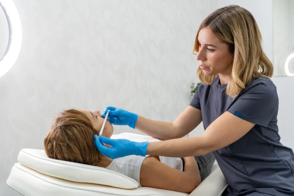 Professional administering facial fillers to female patient